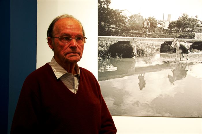 O barbeiro fotógrafo António Marreiros junto a uma das suas fotos na exposição