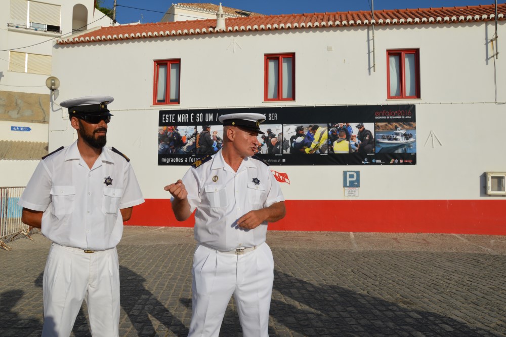 O Agente Ponte e o Agente Rocha, junto às fotografias na parede do edifício do ISN, em Ferragudo