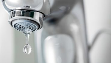 Tap closeup with dreaping waterdrop. Water leaking